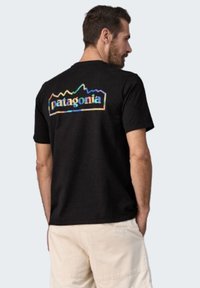 Zwarte katoenen T-shirt met korte mouwen, voorzien van een kleurrijk 'Patagonia'-logo en bergafbeelding op de achterkant.