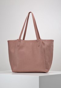Borsa tote in pelle rosa pallido con due manici lunghi, caratterizzata da un design strutturato e una superficie liscia, adatta per l'uso quotidiano.