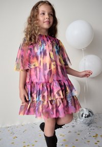 Flerrfarvet lagdelt kjole med korte ærmer, lavet af et gennemsigtigt materiale og med en flæsekant, i nuancer af pink, lilla og gul.