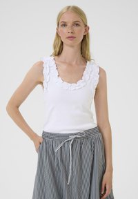 Valge ribaga tank tops, millel on tekstuuriga volangkaelus, koos halli triibulise seeliku ja elastse vöökoha ning nööriga.