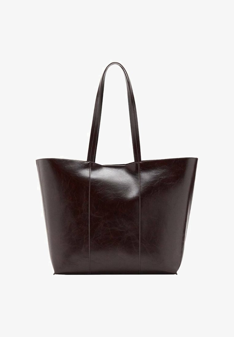 Sac fourre-tout en cuir marron foncé avec une forme structurée, une texture lisse et des anses allongées, présentant trois coutures verticales à l'avant.