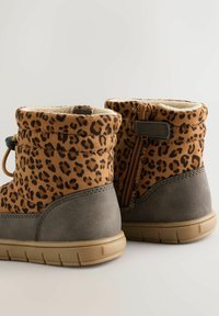 Botine cu imprimeu leopard maro și accente gri, căptușeală călduroasă și fermoar lateral; talpă din cauciuc cu textură pentru o aderență durabilă.
