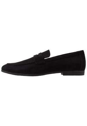 Schwarze Wildlederloafers mit abgerundetem Zeh, genähten Details und einem kleinen Riemen über dem Spann. Strukturiertes Obermaterial und glatte Gummisohle.