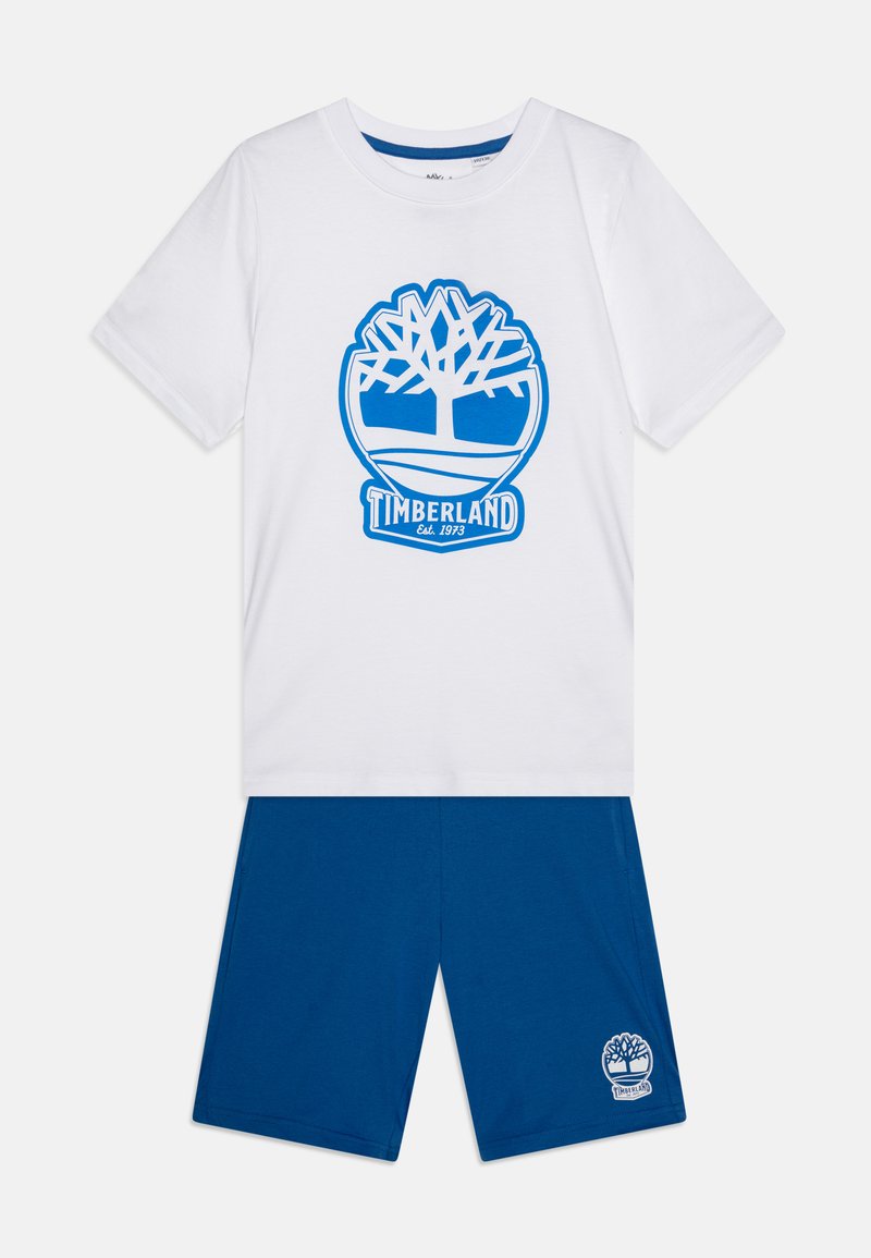 Valge puuvillane T-särk, millel on sinine Timberlandi puu logo ja tekst, koos siniste lühikestega, millel on väike logo. Sujuv tekstuur, vabalt aja veetmise disain.