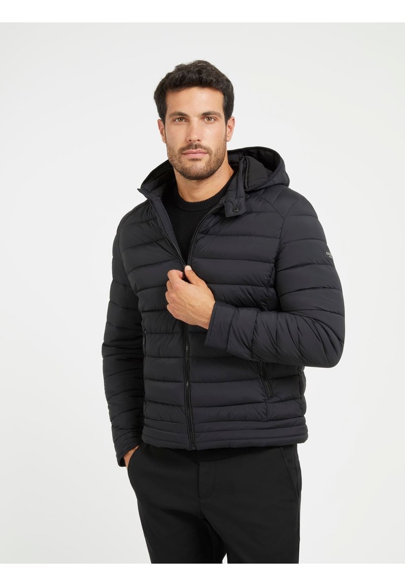 Giacca nera imbottita con cappuccio, chiusura con zip e tasche laterali. Design trapuntato e testurizzato con una silhouette elegante.