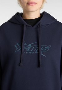Hoodie bleu marine avec une poche kangourou, des cordons de serrage et un logo graphique en teal sur le devant. Tissu doux en mélange de coton avec une coupe décontractée.