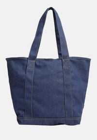 Torba na ramię z denimu w ciemnym niebieskim kolorze, z podwójnymi uchwytami, o prostokątnym kształcie, wzmocnionych szwach i kontrastującym żółtym przeszyciem.