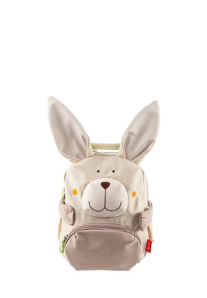 Zaino di un leggero color beige a forma di coniglio, con grandi orecchie, una faccia sorridente, accenti arancioni sulle guance e una tasca frontale con zip e un tirante verde.