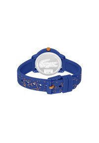 Orologio in silicone blu con cinturino texturizzato che presenta motivi geometrici arancioni, cassa rotonda e una corona arancione. Retro cassa in acciaio inox visibile.