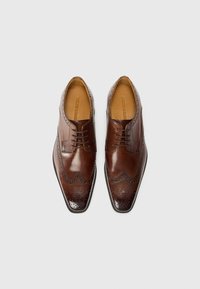 Zapatos de vestir de cuero marrón con diseño de brogue, puntera afilada y cierre con cordones. Presentan perforaciones decorativas a lo largo de los bordes.