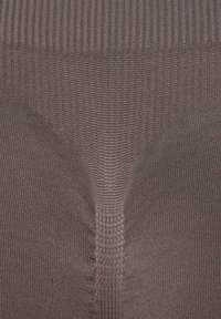 Brown ribbed leggings with a textured pattern. Features seamless design and elastic waistband, providing a snug fit throughout the fabric.