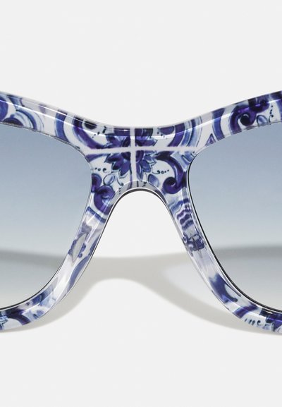 Oversized sunglasses with a clear frame featuring blue and white floral patterns. Gradient grey lenses; smooth, glossy texture.