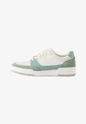 Zapatilla baja con cuero blanco, ante verde claro y detalles de cuero, cierre con cordones y suela de goma texturizada.