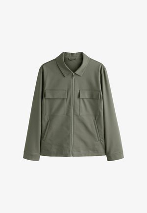 Veste vert olive avec un col pointu, fermeture éclair sur le devant, deux poches poitrine et poches latérales. Fabriquée en tissu lisse et légèrement extensible.