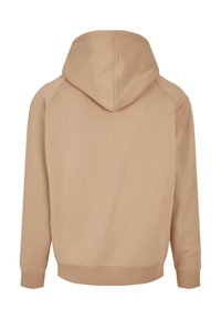 Felpa con cappuccio color beige, caratterizzata da una texture liscia e polsini a coste. Presenta un design classico con una vestibilità rilassata e senza grafiche visibili.
