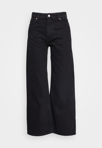 Svarta denimbyxor med breda ben och hög midja, som har två framfickor, knäppning med knapp och kopparnitar.