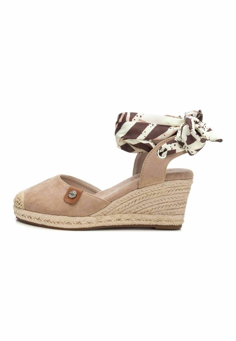 Sandalo con zeppa in suede beige, dotato di suola in juta intrecciata, con un cinturino alla caviglia in tessuto a motivo marrone e crema annodato a fiocco.