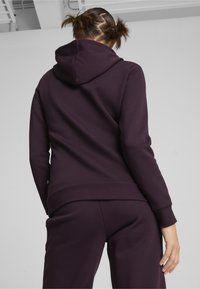 Felpa con cappuccio viola, con texture in pile, polsini e orlo a coste. Il design presenta una tasca a marsupio e una vestibilità comoda.