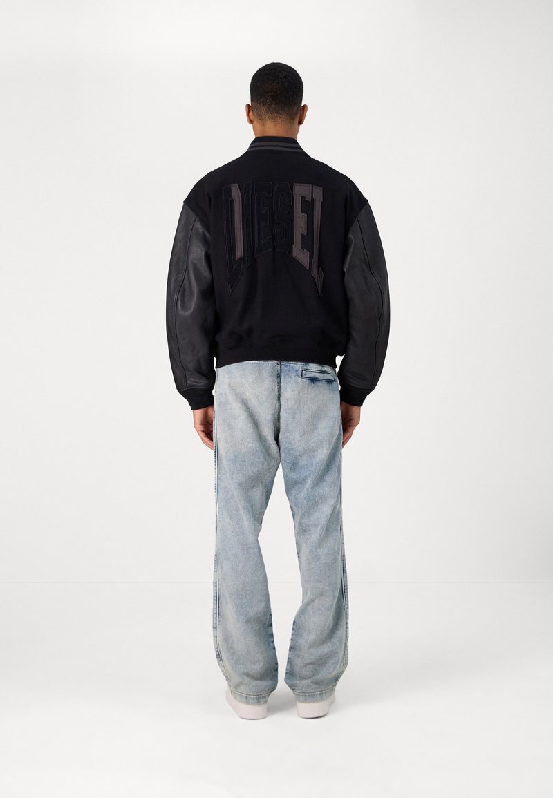 Veste bomber noire avec manches en cuir et logo "DIESEL" brodé, associée à un jean en denim bleu clair. Texture lisse, coupe décontractée.