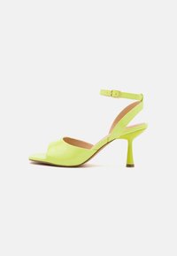 Open-toe lime green leather heeled sandal with ankle strap and gold buckle, featuring a slim mid-height heel and quilted texture.