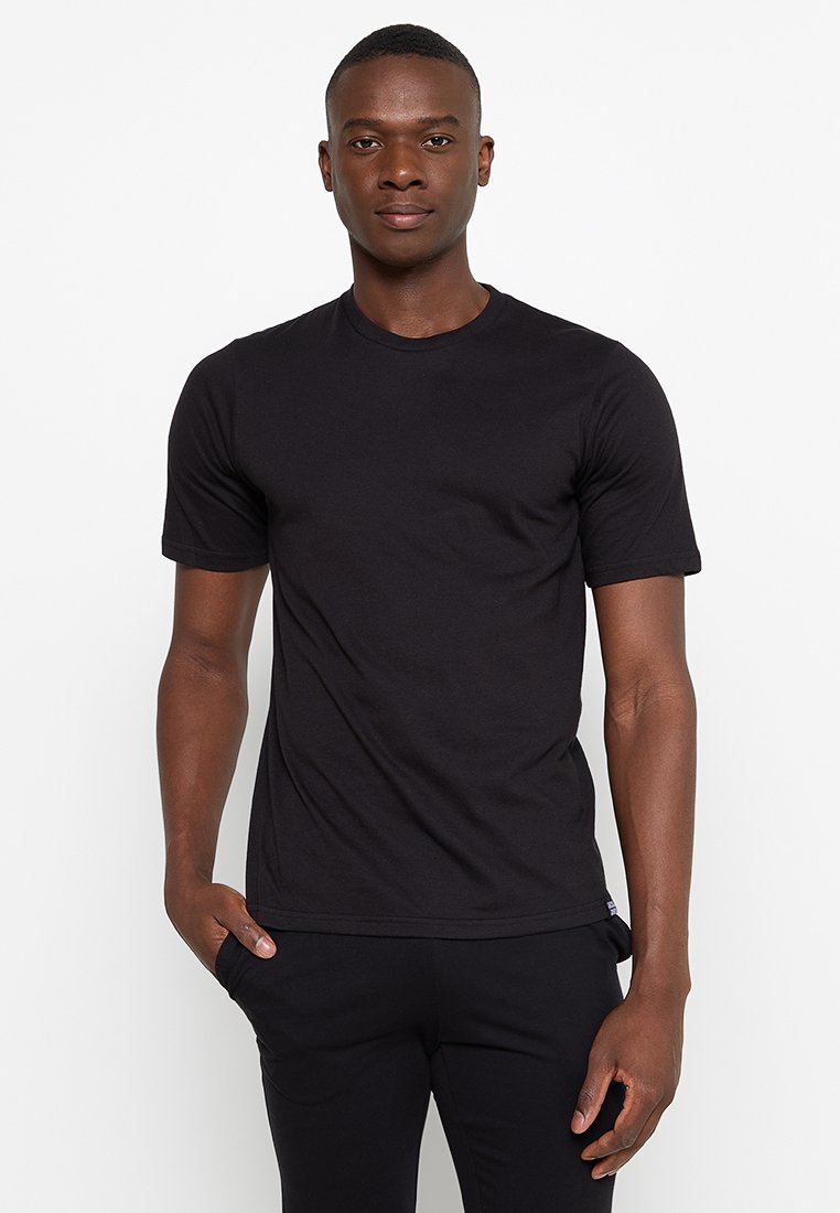 Schwarzes Baumwoll-T-Shirt mit rundem Halsausschnitt, kurzen Ärmeln und taillierter Form. Glatte Textur ohne sichtbare Muster oder Akzente.