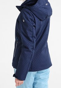 Dunkelblau isolierte Jacke mit strukturiertem Muster, verstellbare Kapuze und mit Reißverschluss gesicherten Seitentaschen. Verfügt über eine taillierte Passform und elastische Bündchen.