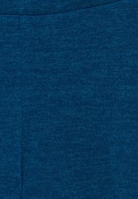 Gros plan d’un tissu tricoté bleu montrant une texture fine des mailles et des variations subtiles de couleur.