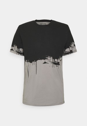 Koszulka z krótkim rękawem, z czarną górną połową i szarą dolną połową, z czarnymi plamami farby wokół środka i rękawów.