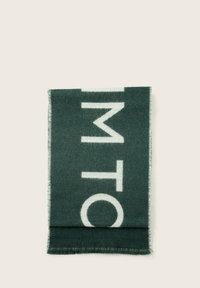 Zielony szalik wykonany z wełny z dużym białym napisem. Krawędzie mają postrzępiony detal. Prostokątny kształt o miękkiej teksturze.