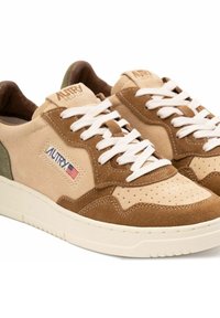 Sennep- og beige ruskinds sneakers med perforerede detaljer, hvide snørebånd og et grønt accentpanel, der har AUTRY-logoet.