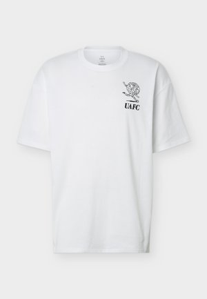 Biele tričko s krátkym rukávom s malou čiernou grafikou futbalistu kopajúceho do glóbusu a textom "UAFC" na hornej ľavej časti hrudníka.