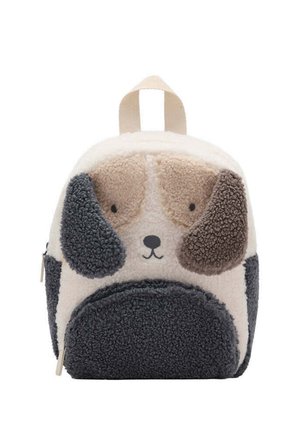 Pequeña mochila suave diseñada como la cara de un perro de peluche con orejas caídas en beige, marrón y gris oscuro, con asa superior y cierre de cremallera.