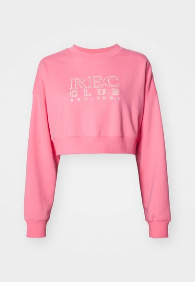 Rózsaszín, rövidített pamut pulóver hosszú ujjal, bordás kerek nyakú, fehér "REC CLUB EST. 1980" felirattal.
