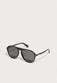 Ochelari de soare negri cu lentile întunecate, formă rotundă, cadru din plastic și un accent curcubeu pe tâmplă. Logo-ul Polaroid pe lateral.