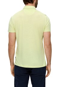 Koszulka polo w jasnym żółtym kolorze, z krótkimi rękawami, o luźnym kroju i klasycznym kołnierzyku. Wykonana z gładkiego, teksturowanego materiału.