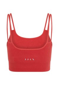 Reggiseno sportivo rosso con spalline sottili, texture a coste e design senza cuciture. Presenta un logo sul davanti, evidenziando uno stile minimalista.