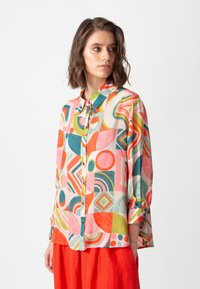 Kleurrijk overhemd met knopen, voorzien van een geometrisch patroon met vormen in roze, oranje, groen en blauw. Zachte stof met lange mouwen en een kraag.