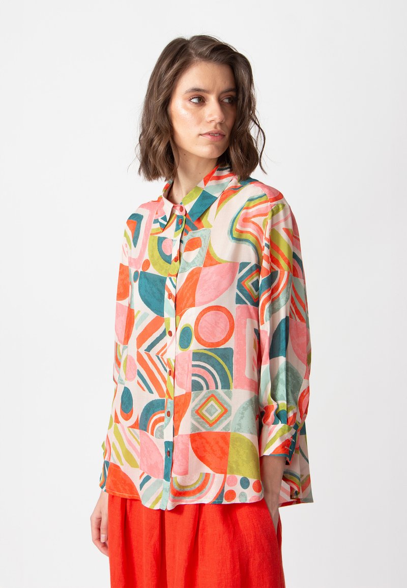 Kleurrijk overhemd met knopen, voorzien van een geometrisch patroon met vormen in roze, oranje, groen en blauw. Zachte stof met lange mouwen en een kraag.