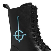 Μαύρη δερμάτινη μπότες με κορδόνια, με χαρακτηριστικό μπλε κεντητό κυκλικό σύμβολο, υφή επιφάνειας και μαύρο κορδόνι.