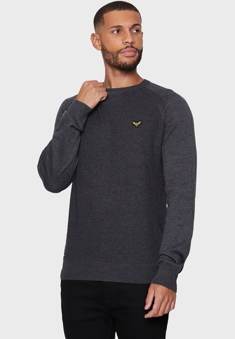 Anthrazitgrauer gestrickter Pullover mit strukturiertem Muster, Rundhalsausschnitt, gerippten Bündchen und Saum sowie einem kleinen gelben Logo-Detail auf der Brust.