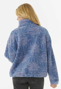 Pull en polaire bleu clair avec un design texturé et à motifs. Doté d'un col haut et d'une coupe confortable. Matériau doux et chaud.