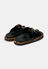 Footwear neri con tre cinturini trasparenti, suola con motivo leopardato e texture liscia. Presenta un leggero design con piattaforma.