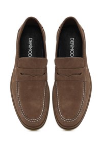 Mocassins en suède marron avec des coutures blanches et une sangle décorative. L'intérieur est noir avec un logo. Conception à bout rond et plat.