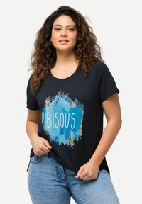 Marineblauw T-shirt van zachte stof, met een blauw en grijs artistiek spetterdesign en de tekst "BISOU" in het wit. Ronde hals en korte mouwen.