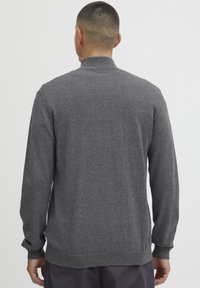 Gray sweater with a high collar, long sleeves, and ribbed cuffs and hem. Soft texture and classic design suitable for casual wear.