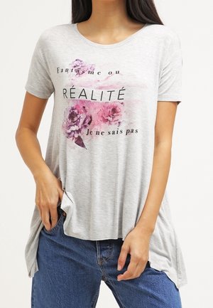 T-shirt grigio a maniche corte con stampa floreale in viola e rosa, con testo nero in un carattere moderno. Vestibilità ampia e rilassata con spacchi laterali.