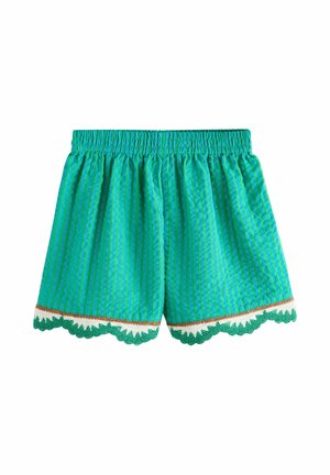 Grønne shorts med striber, elastisk talje og bølget kant i grøn, hvid og brun langs kanten.
