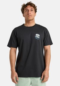 T-shirt en coton noir à manches courtes avec un graphique coloré de marguerite et du texte sur la poitrine gauche, coupe décontractée et col rond.