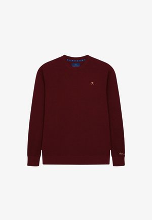 Burgunderfarbener Strickpullover mit Rundhalsausschnitt. Verfügt über gerippte Bündchen und Saum, ein strukturiertes Muster und ein kleines goldenes Logo auf der Brust.