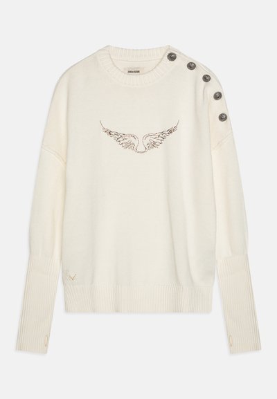 Kreemitooni kootud sviiter, millel on tiiva tikandimuster. Omab soonikuid varrukaotsi ja kaelust ning dekoratiivnuppe õlal.